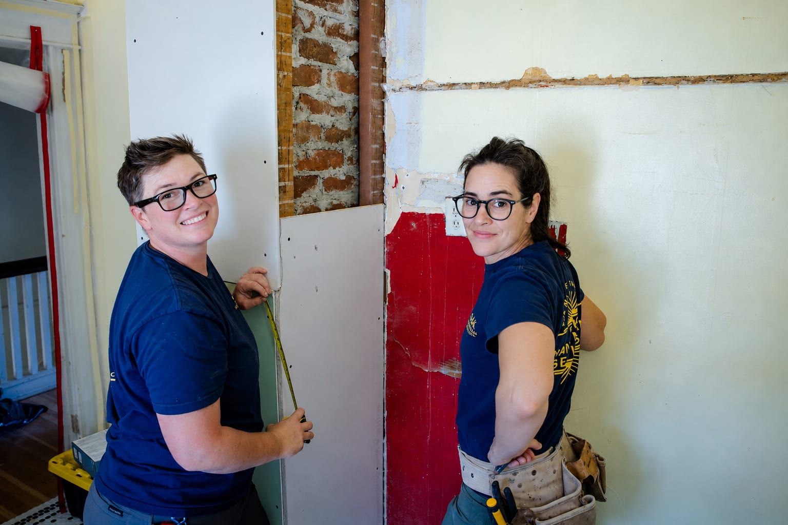 SJ and Lisa on the job, pausing for a photo during drywall work